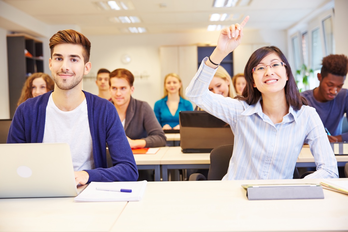 Estudiante asiática levantando la mano en un aula universitaria